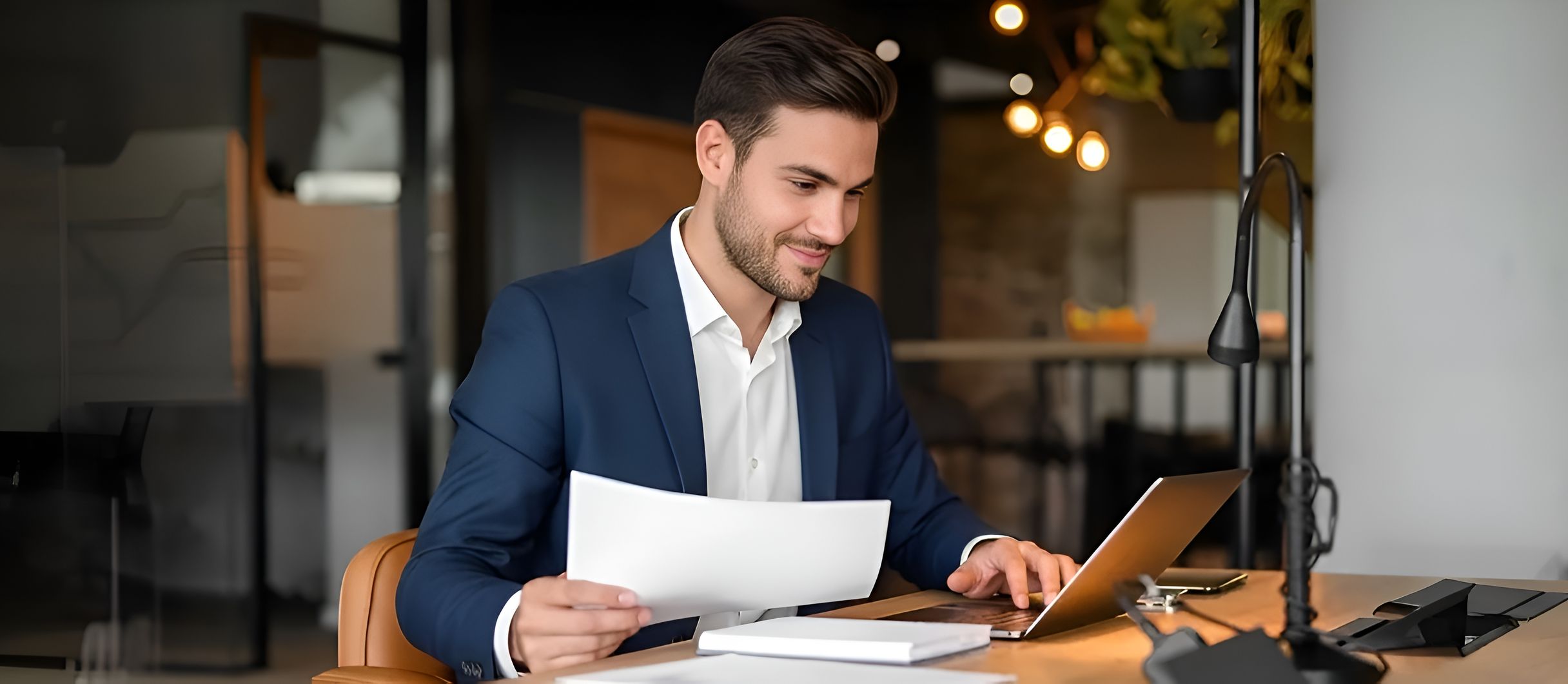 M&A professional reviewing documents at a laptop